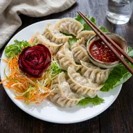 Steamed momos with a beetroot rose garnish